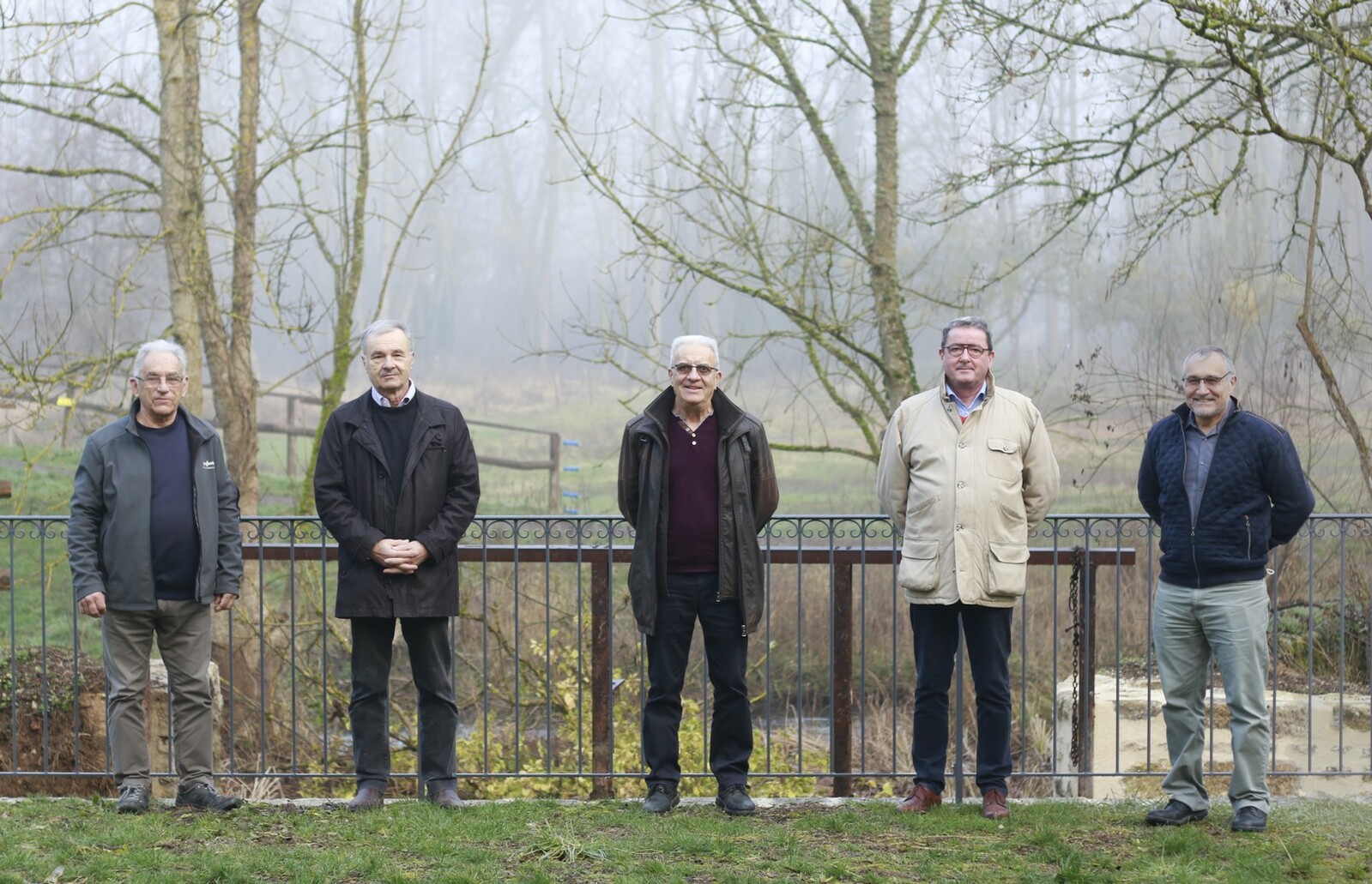 Photo des membres du bureau devant le bras usinier du moulin de la porte